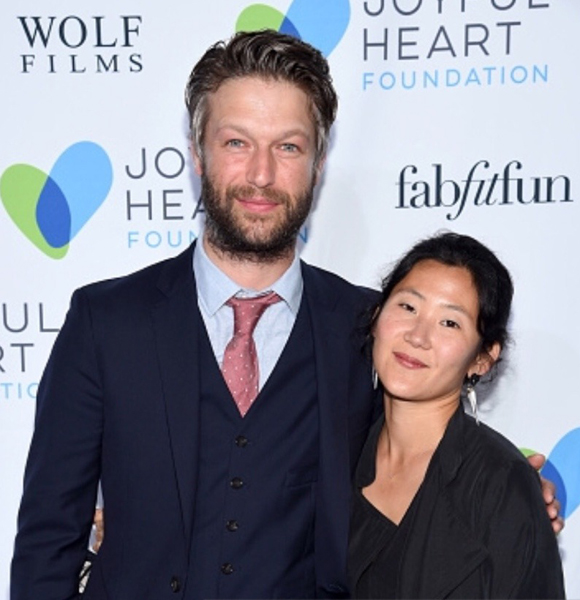 Peter Scanavino hugging his wife Lisha Bai during an event for a good cause
